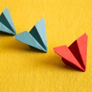 row of paper plane on yellow fabric background leadership concept