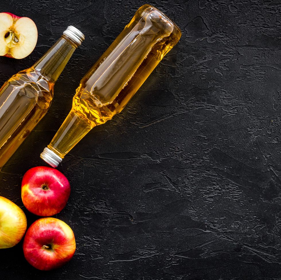 apple cider vinegar bottle on black background top view