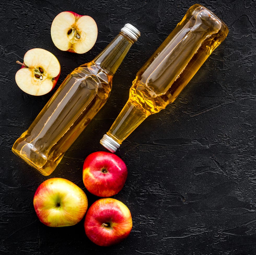 apple cider vinegar bottle on black background top view