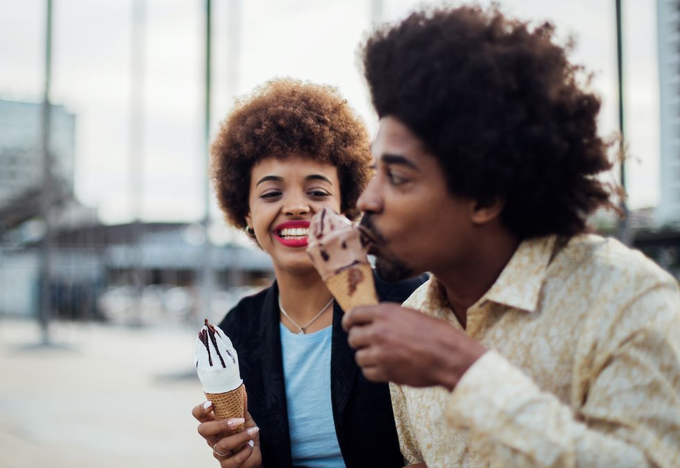 young african american couple eating ice cream and enjoying their honeymoon together