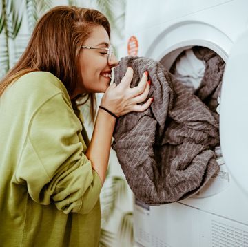 young woman takes laundry out of the washing machine