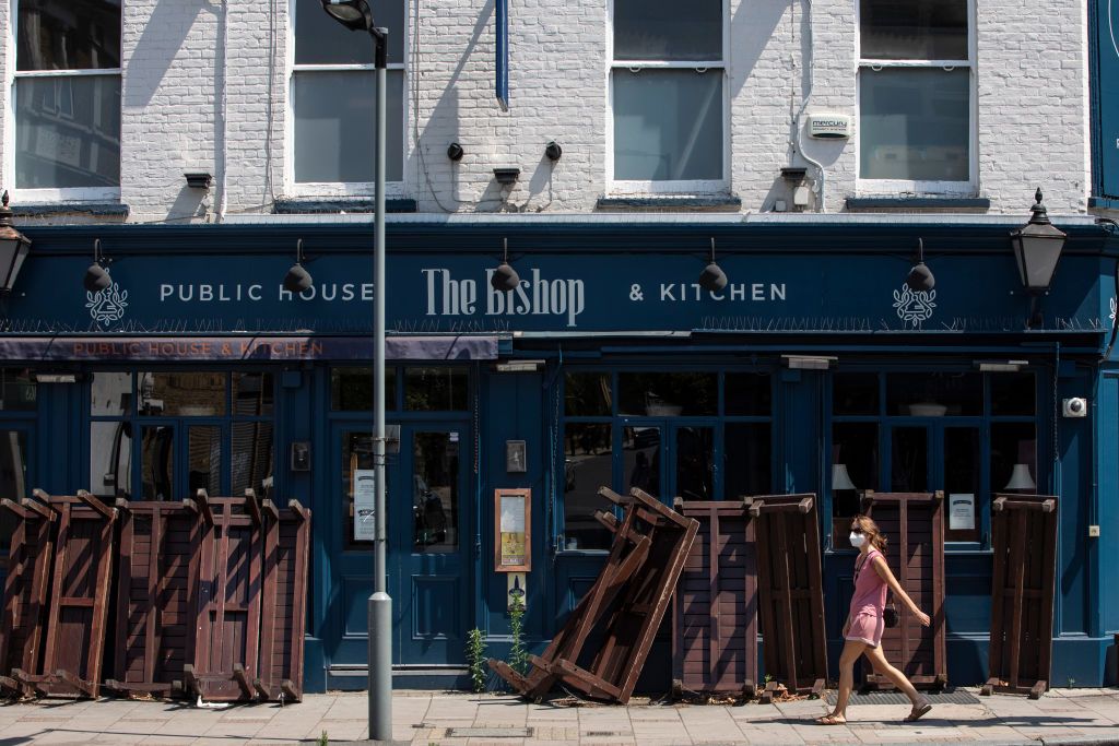 london, england   june 24 a woman wearing a face mask walks past a closed pub in dulwich on june 24, 2020 in london, england yesterday, the prime minister boris johnson announced the reopening of restaurants, pubs, hairdressers and hotels on july 04 and the introduction of a “one metre plus” social distancing rule photo by dan kitwoodgetty images