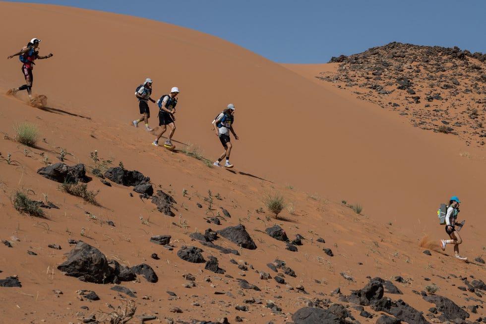competitors take part in stage 4 of the 37th edition of the marathon des sables between jebel zireg and jdaid in the moroccan sahara desert, near ramlia central morocco, running down a steep slope of sand.