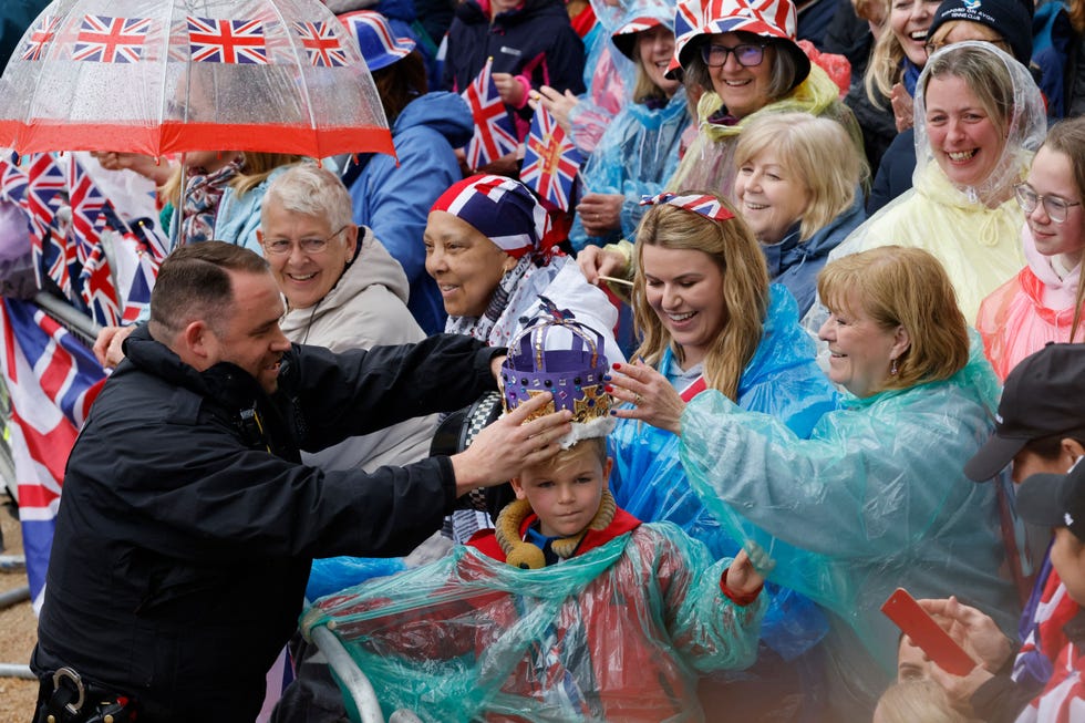 a police officer poses with a young member of the public ahead of the kings procession, a two kilometres stretch from buckingham palace to westminster abbey, as they wait for britains king charles iii and britains camilla, queen consort to pass in the diamond state coach, in central london, on may 6, 2023 ahead of their coronations the set piece coronation is the first in britain in 70 years, and only the second in history to be televised charles will be the 40th reigning monarch to be crowned at the central london church since king william i in 1066 outside the uk, he is also king of 14 other commonwealth countries, including australia, canada and new zealand camilla, his second wife, will be crowned queen alongside him and be known as queen camilla after the ceremony photo by carlos jasso afp photo by carlos jassoafp via getty images