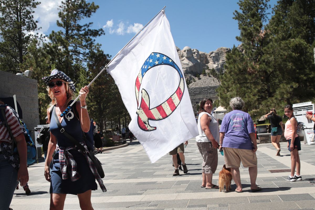 keystone, south dakota   july 01 a donald trump supporter holding a qanon flag visits mount rushmore national monument on july 01, 2020 in keystone, south dakota president donald trump is expected to visit the monument and speak before the start of a fireworks display on july 3 photo by scott olsongetty images