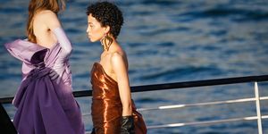 paris, france   july 05 a model wears a large golden earring, a bronze color shiny lustrous silky off shoulder dress, black leather gloves, during the balmain sur seine performance, on a barge on the seine river, on july 05, 2020 in paris, france photo by edward berthelotgetty images