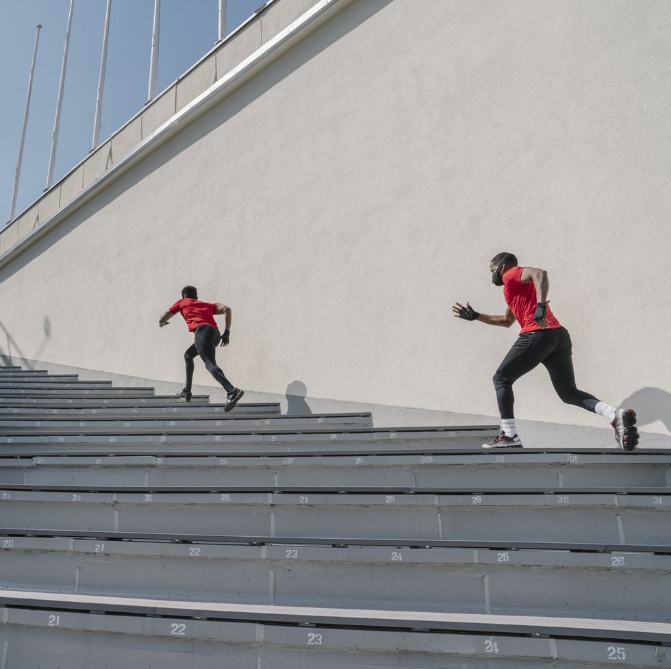 sportsmen wearing face masks running up stairs mens health