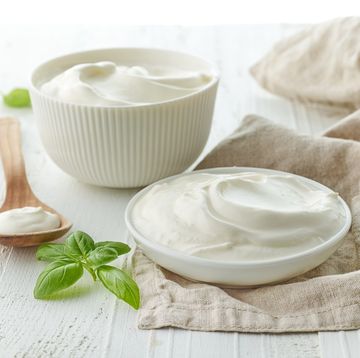 bowls of sour cream or yogurt on white wooden table