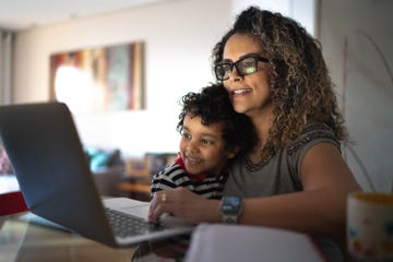 woman on computer at home, carrying young son