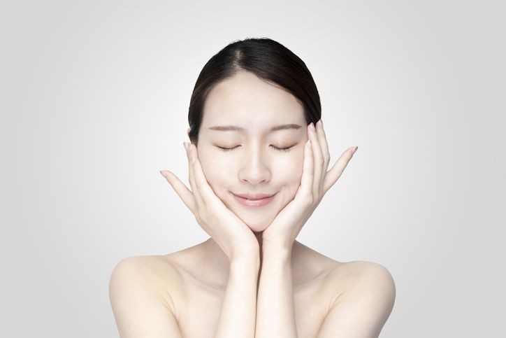 asian young woman touching face with her hand in relaxed expression
