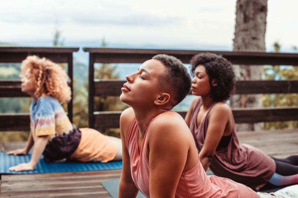 close up of a group of female friends doing yoga together on the patio