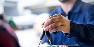 Car repairman giving car keys to customer car repairman giving car keys to customer after success car repairing in garage