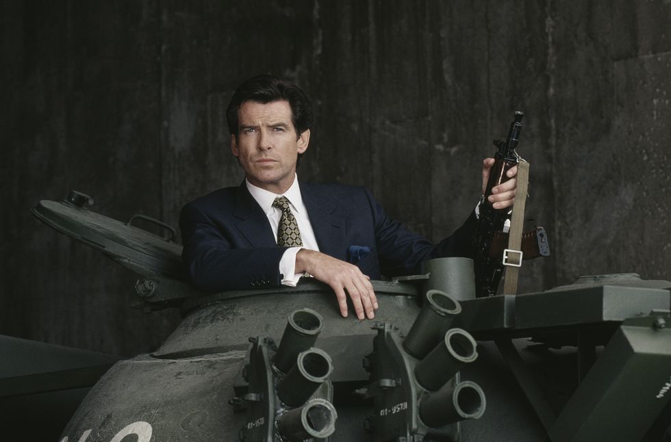 irish actor pierce brosnan poses in the hatch of a russian t55 main battle tank holding a kalashnikov automatic rifle, in a publicity still for the james bond film goldeneye, 1995 photo by keith hamsheregetty images