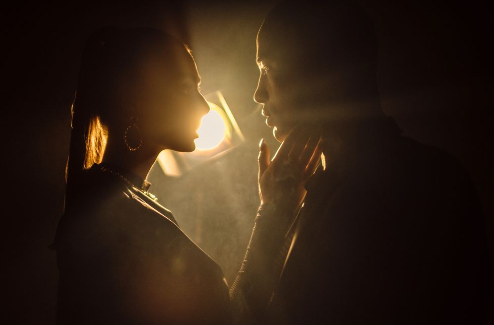 sensuous young woman close to kiss man against light background silhouette of man and woman closing to kiss shadow of two lovers