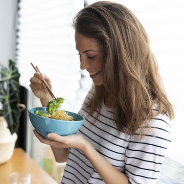 a woman eating a bowl of food