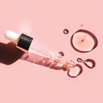 flat lay liquid gel or serum drop with pipette on pink background in macro