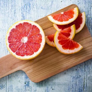 a sliced red grapefruit on a cutting board