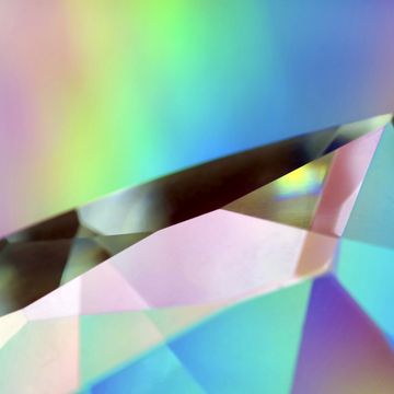 close up of a faceted glass prism with rainbow light effects