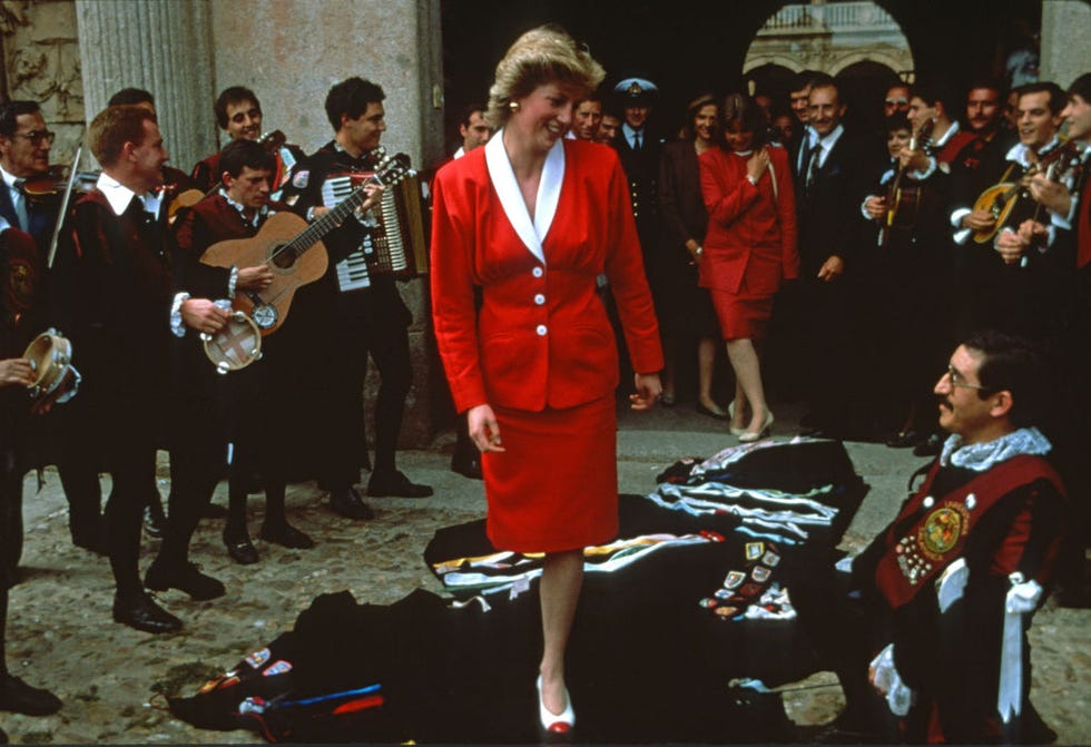 salamanca, spain april 23 diana, princess of wales, wearing a red skirt suit with a white collar designed by bruce oldfield, walks over musicians cloaks which have been draped in the floor as a mark of respect, on april 23, 1987 in salamanca, spain photo by anwar husseingetty images