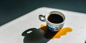 espresso cup filled with spilled coffee around