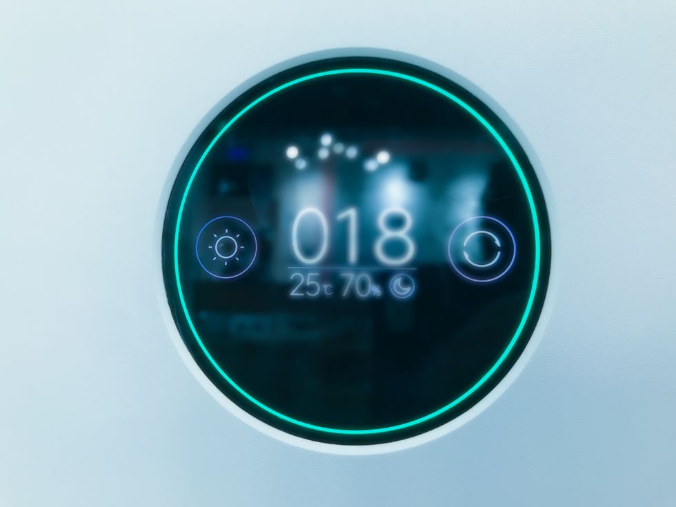 digital thermostat on blue light background of the air conditioning