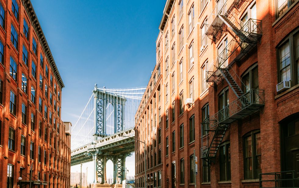 one of the most iconic views of new york city looking down washington street in dumbo, brooklyn towards the manhattan bridge