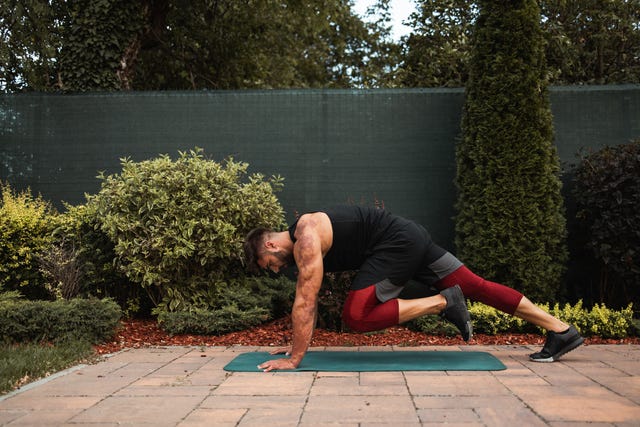 shot of a shirtless muscular young man doing strength exercise on yoga mat in the backyard