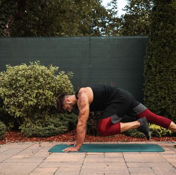 shot of a shirtless muscular young man doing strength exercise on yoga mat in the backyard