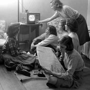 women watching television and reading a newspaper