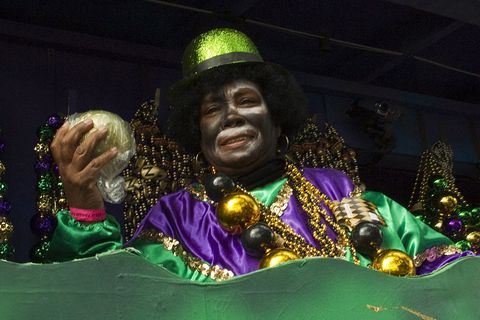 members of the krewe of zulu toss out elaborately decorated zulu coconuts