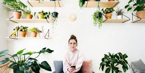 vrouw op stoel omringd door planten