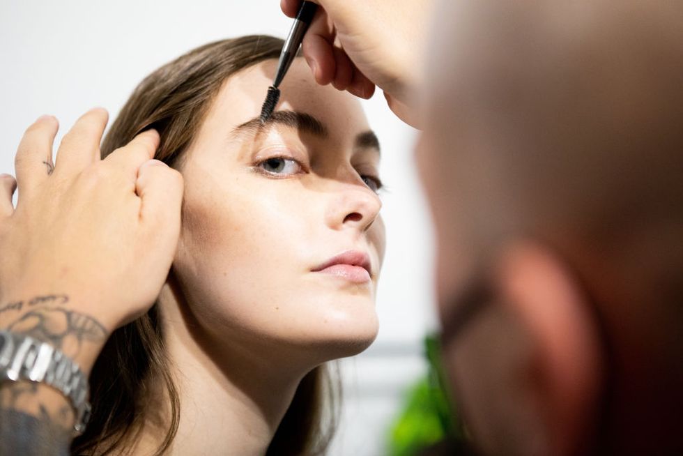 milan, italy   september 27 a make up artist does the final touch  of gel eyebrow during the line up before the show is seen backstage at the shirt fashion show during the milan womens fashion week on september 27, 2020 in milan, italy photo by rosdiana ciaravologetty images