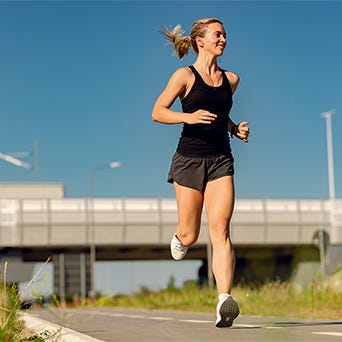 Below view of female runner jogging outdoors. low angle view of female athlete running outdoors. copy space.