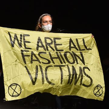 paris, france   september 29 a woman holds a banner which reads we are all fashion victims as she walks on the runway during the dior womenswear springsummer 2021 show as part of paris fashion week on september 29, 2020 in paris, france photo by stephane cardinale   corbiscorbis via getty images