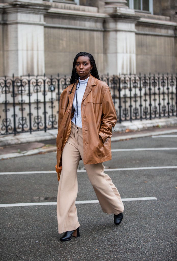 paris, france   october 02 a guest is seen wearing brown leather jacket, bucket bag, white top, beige pants outside yohji yamamoto during paris fashion week   womenswear spring summer 2021  day five on october 02, 2020 in paris, france photo by christian vieriggetty images