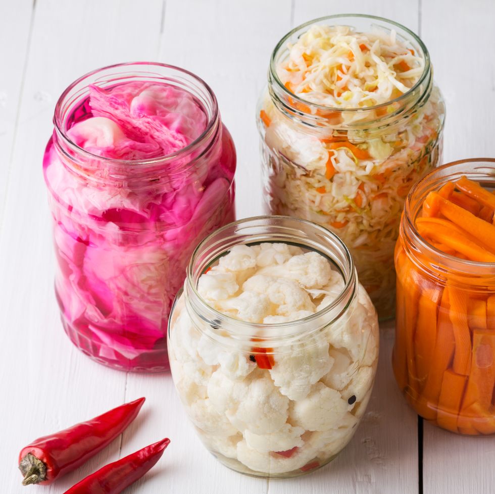 fermented vegetables homemade marinated cabbage with carrot and cucumbers, sauerkraut sour in glass jars preserved canned vegetables, superfoods and vegetarian food