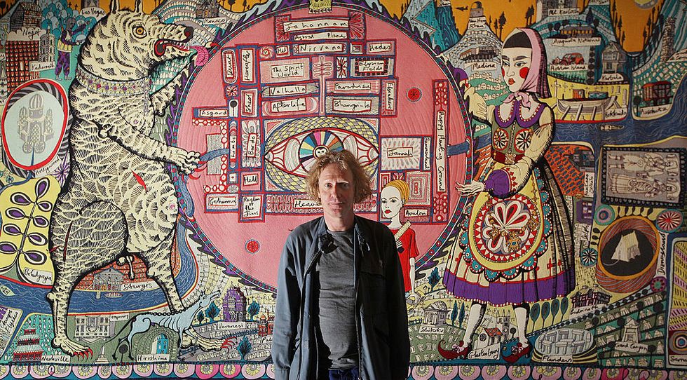 london, england   october 05  grayson perry stands in front of his tapestry map of truths and beliefs at the tomb of the unknown craftsman exhibition at the british museum on october 5, 2011 in london, england british artsist grayson perry has created  this exhibition to showcase his new works alongside objects made by unknown men and women throughout history from the british museums collections  photo by peter macdiarmidgetty images