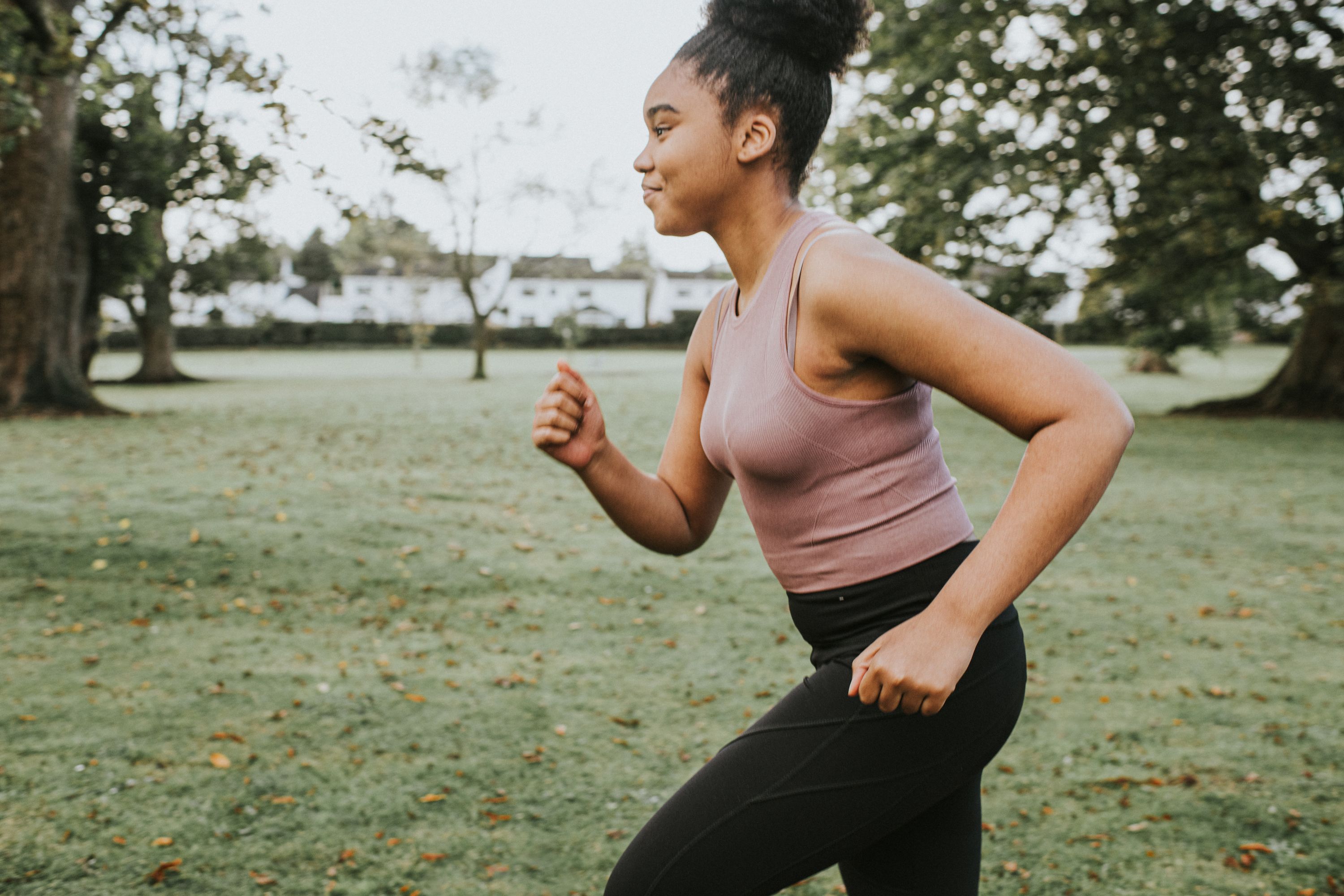 Photo of posing athletic female. Smiling woman with fit, curvy body doing  sport exercises. Model having slim, stunning figure, wearing sport trousers  and top, also sneackers for professional run. Stock-bilde