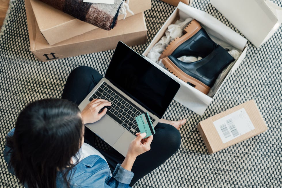 high angle view of a young asian woman shopping online on laptop, making payment with credit card enjoying seasonal sales shopaholic concept