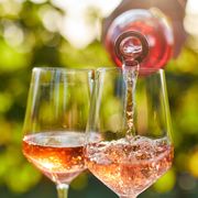 pouring rose wine into glasses from a bottle