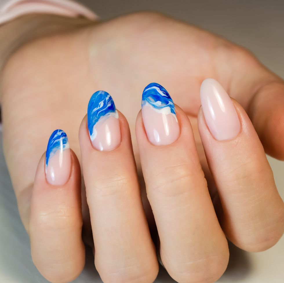 hands of a young woman the nails are covered with a light colored gel polish with a bright design manicure ideas