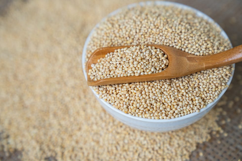 millet in spoon above bowl, top view,millet
