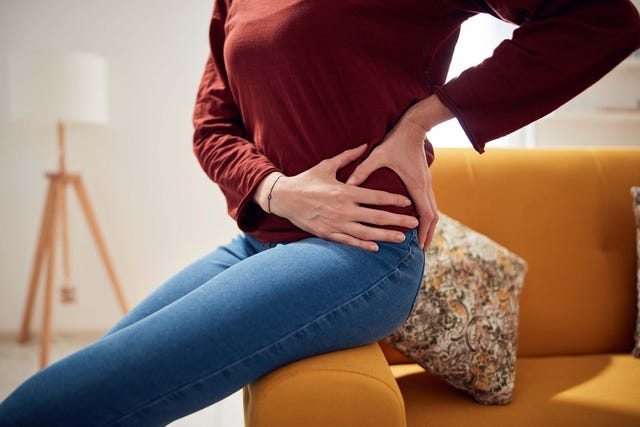 woman with strong hip pain at home.