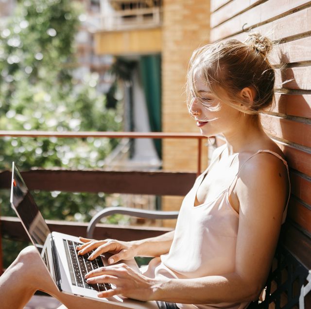 young woman working on laptop in balcony