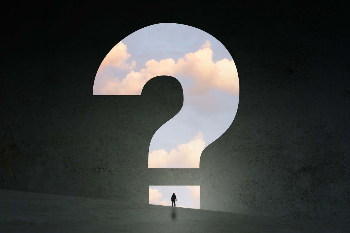 a concept, of a man silhouetted against a question mark and clouds