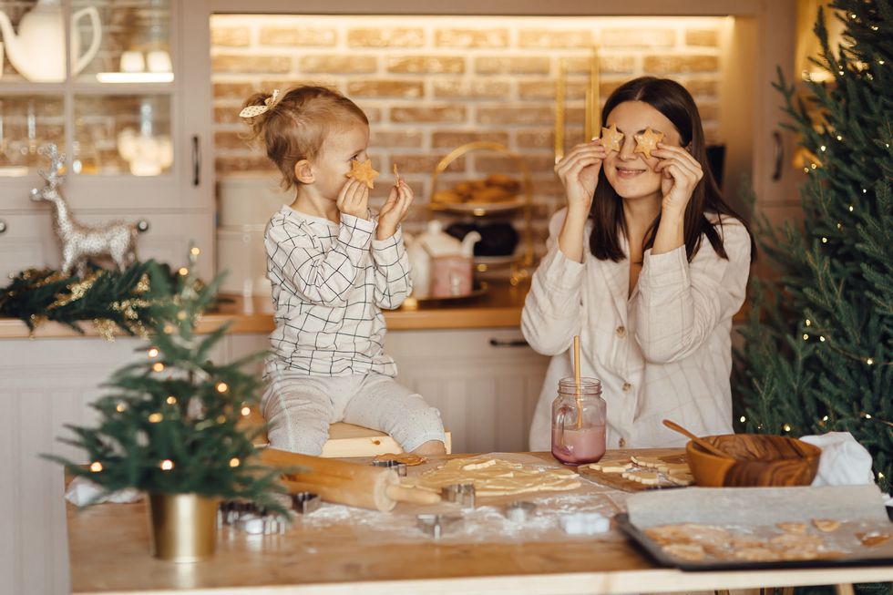happy daughter and beautiful mother preparing christmas cookies in kitchen at home