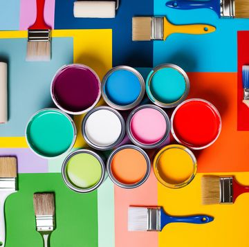 top view colorful composition of various open cans with bright paints arranged with assorted paintbrushes and roller on multicolored background representing concept of repair and renovation