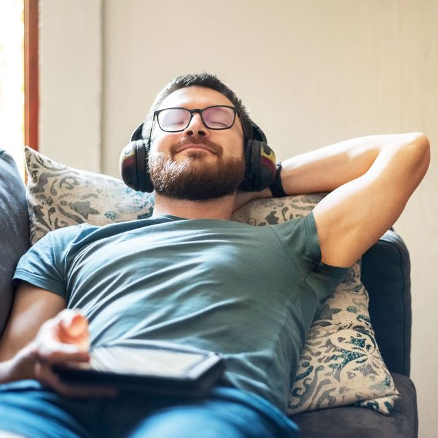 man reclining on sofa wearing headphones