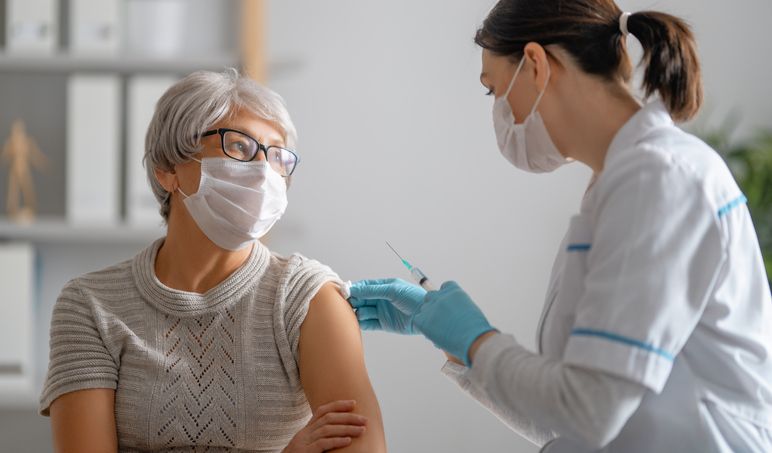 doctor giving a senior woman a vaccination virus protection covid 2019