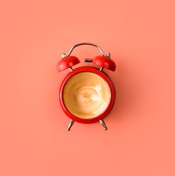 Red alarm clock with empty coffee inside wake up alarm coffee concept